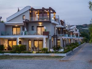 a large white building with a lot of windows at Argilos & Argilos Deluxe Residential Complexes in Ofrínion
