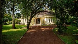 a large white house with trees in front of it at Coconut Grove - 4 Bed Pool Villa with Cook in Ahangama