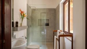 a bathroom with a shower and a toilet and a sink at Coconut Grove - 4 Bed Pool Villa with Cook in Ahangama +21 photos