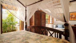 a bedroom with a bed with a table and a chair at Coconut Grove - 4 Bed Pool Villa with Cook in Ahangama