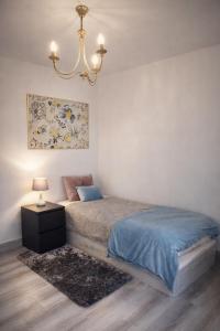 a bedroom with a bed and a chandelier at Albufeira New House in Albufeira +36 photos