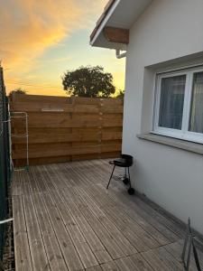 a deck with a fence and a chair on it at Studio cosy avec piscine à 10 min Hossegor in Saint-Vincent-de-Tyrosse