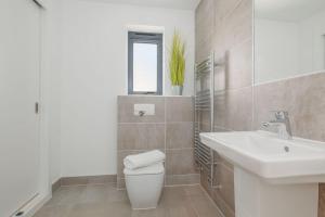 a white bathroom with a sink and a toilet at Stonehaven in Warmwell +27 photos