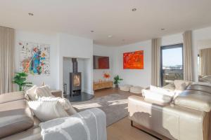 a living room with white furniture and a fireplace at Stonehaven in Warmwell