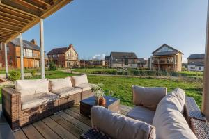 a patio with a couch and a table on a deck at Stonehaven in Warmwell