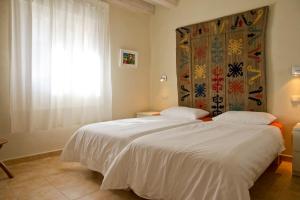 two beds in a hotel room with a window at Casa Gailupa in San Martín