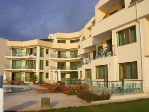 a large apartment building with a patio and a swimming pool at Seaside Apartment Golf Coast in Topola