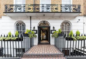 een wit huis met een zwarte deur en een balkon bij Park Avenue Baker Street in Londen