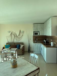 a kitchen and living room with a couch and a table at Seaside Apartment Golf Coast in Topola