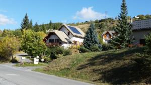 EnchastrayesにあるStudio Barcelonnette Ubaye, Provenceの道路横の丘の上の家