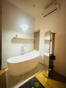 a large white bath tub in a bathroom at Tue Anh Homestay in Cồn Giả Viên +63 photos