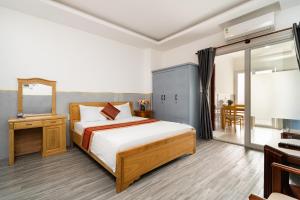 a bedroom with a large bed and a desk at Helen Airport Hotel in Ho Chi Minh City +58 photos
