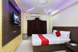 a hotel room with a bed and a tv at Hotel MB International in Mysore