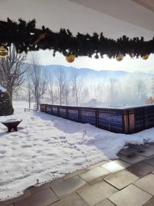 a snow covered patio with a fence and a bench at Pension Egg'spresso in Egg