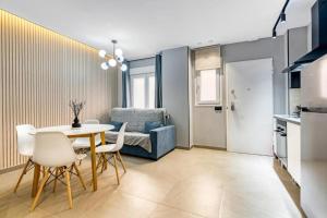 a living room with a table and a blue couch at City Scape Suites in Valencia +25 photos