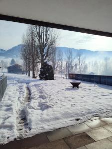 a snow covered patio with a bench in the snow at Pension Egg'spresso in Egg