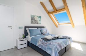 a bedroom with a bed with blue sheets and a window at Villa Panorama in Omiš