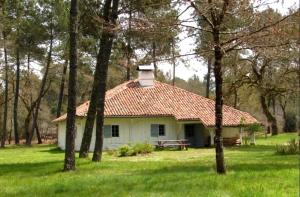 a white house with a red roof in the grass at Le bourrut in Luglon