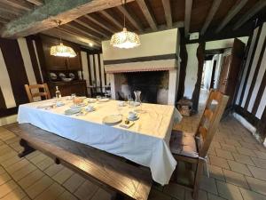 a dining room with a table and a fireplace at Le bourrut in Luglon