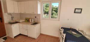 a small kitchen with a table and a window at 205 Mata, 80m vom Strand in Stanići