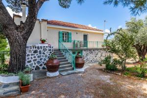 a house with a staircase and a tree at Anemoperasma - Peaceful Stay in an Olive Grove in Stafylos