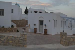 a row of white buildings with a door and a wall at Aegean Muses in Lipsoi