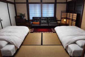 a living room with two beds and a couch at 緋乃里 in Nagahama