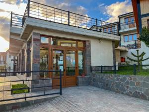 a house with a wooden door and a balcony at Balcones del Beagle Apart in Ushuaia
