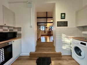 a kitchen with a stairway leading to a dining room at Hele Bay Cottage in Ilfracombe