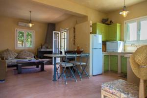 StavrosにあるHomer's Viewのキッチン(緑のキャビネット、テーブル、椅子付)