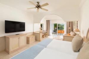 ein Schlafzimmer mit einem großen Bett und einem Flachbildfernseher in der Unterkunft Gran Tagoro Family & Fun Playa Blanca in Playa Blanca