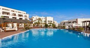 ein großes Schwimmbecken vor einigen Gebäuden in der Unterkunft Gran Tagoro Family & Fun Playa Blanca in Playa Blanca + 77 Fotos