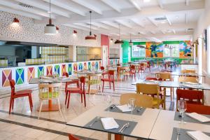 ein Restaurant mit Tischen und Stühlen und farbenfrohen Wänden in der Unterkunft Gran Tagoro Family & Fun Playa Blanca in Playa Blanca