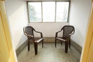 two chairs sitting in a room with a window at Hotel Evergreen in Āsansol