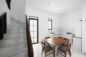 a dining room with a wooden table and chairs at Arumi Experience Tasikmalaya Syariah in Tasikmalaya