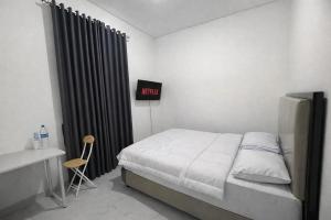 a bedroom with a bed and a sign that reads hotel at Arumi Experience Tasikmalaya Syariah in Tasikmalaya