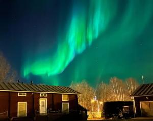 an image of the aurora in the sky over a house at Apartment Suutarintie - Authentic Lappish experience by the River in Rovaniemi