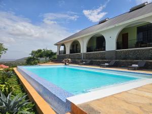 a swimming pool in front of a building at Villa Miamba in Zame