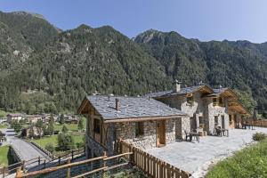 a house in the mountains with a wooden fence at Agriturismo Alle Baite in Branzi
