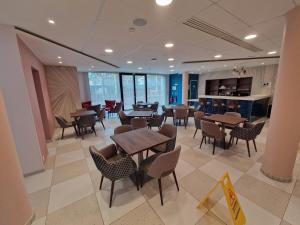 a restaurant with tables and chairs in a room at DOMITYS - Les Cristaux in Le Creusot