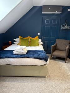 a blue bedroom with a bed and a chair at Hotel Plas Hyfryd in Narberth +72 photos
