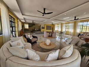 a large living room with couches and a ceiling fan at Villa Miamba in Zame