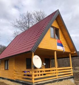 a large wooden house with a red roof at Vikendica Tavna in Bijeljina