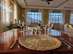 a wooden table with plates and wine glasses on it at Villa Miamba in Zame