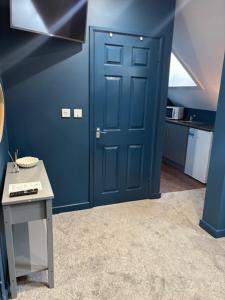 a blue door in a room with a table at Hotel Plas Hyfryd in Narberth
