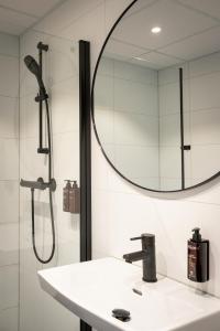 a bathroom with a shower and a sink and a mirror at Quality Hotel Grand Steinkjer in Steinkjer