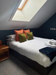a bedroom with a bed with colorful pillows on it at Hotel Plas Hyfryd in Narberth