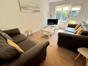 a living room with two couches and a table at Large 2 bedroom house in Wombridge