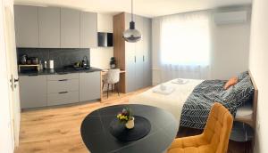 a room with a bed and a table and a kitchen at Ahat apartment- Modern stay near center & free parking in Maribor