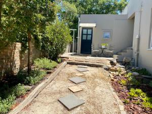 a garden with stepping stones in front of a house at Cinsaut Accommodation in Malmesbury